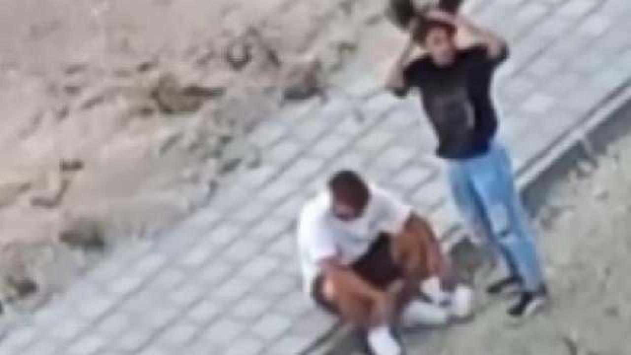 Genç kız, kaldırımda oturan erkeği tartaklayıp tokat attı