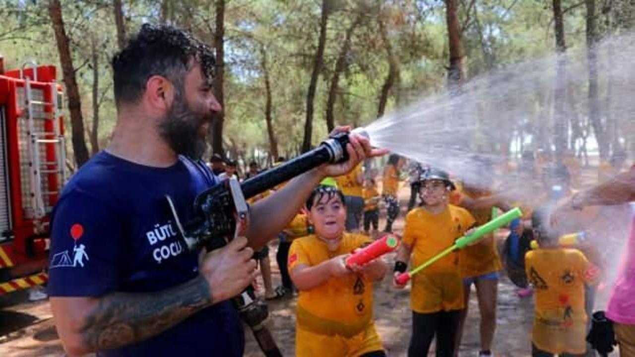 Sıcaktan bunalan çocuklar itfaiye erleri ile su savaşı yaptı