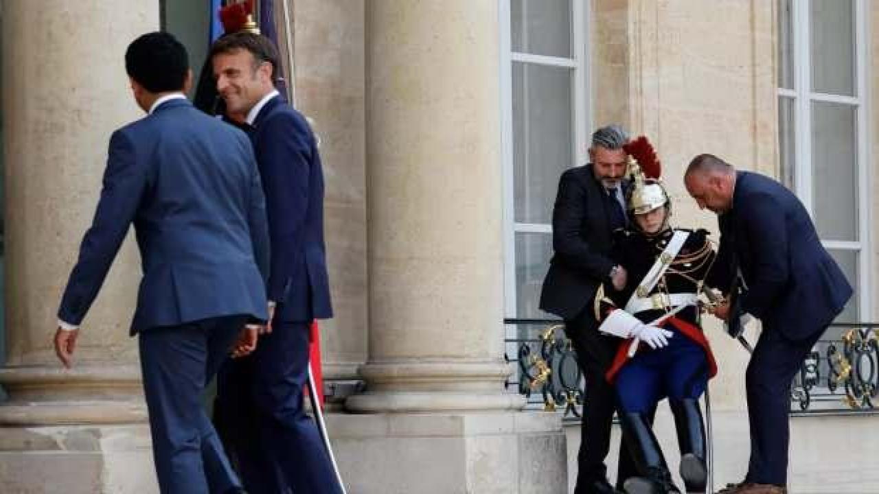 Yanındaki muhafız sıcaktan bayıldı Macron poz vermeye devam etti